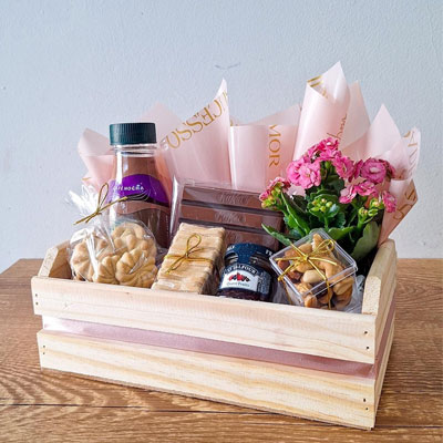 Cesta Mimo em caixote de pinus com Frappuccino Starbucks, biscoitinhos amanteigados, mini torradas, geleia, chocolate, mix de castanhas e flor Kalanchoe